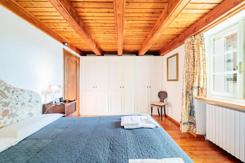 a bedroom with a large bed with a wooden ceiling at La Meridiana in Carrù