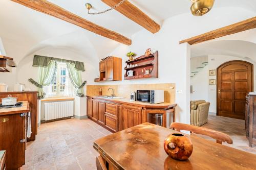 a kitchen with wooden cabinets and a wooden table at La Meridiana in Carrù