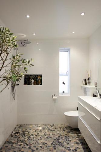 a white bathroom with a toilet and a window at Utsikten i Bua in Kungshamn