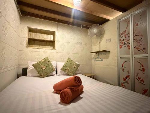 a bedroom with a bed with two towels on it at Dou Houz Georgetown in George Town