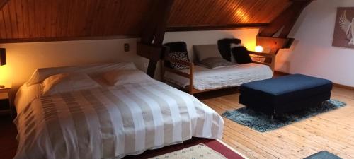a bedroom with a bed and a chair in it at La Petite Ecole de la Baie in Pontorson