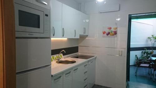 cocina blanca con fregadero y microondas en Apartment Periañez, en Alicante