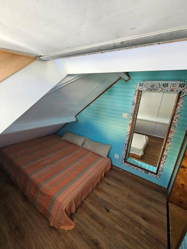 a small room with a bed and a mirror at La splendide Coralline in La Saline Les hauts 