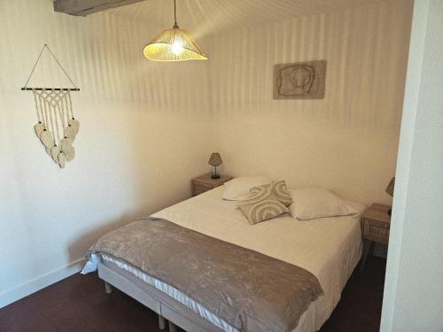 a bedroom with a large bed with a lamp and a bed sidx sidx sidx at Chez collette in Chablis