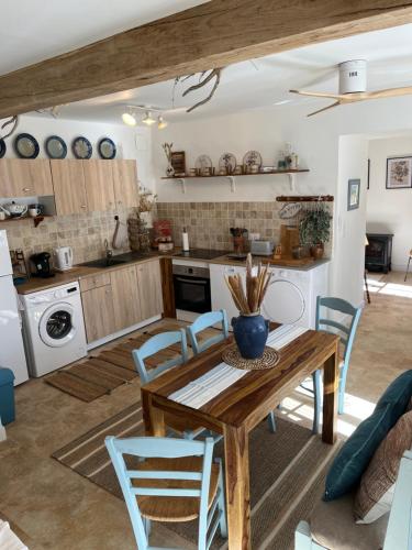 Sunshine cottages في فونتيرفارد لو أباي: مطبخ وغرفة طعام مع طاولة وكراسي خشبية