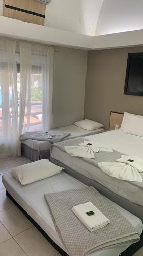 a group of beds in a room with a window at AJ TERMAS HOTEL IRAÍ in Iraí