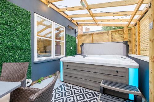 a hot tub on a patio with a table and chairs at Hambleton House in Derby