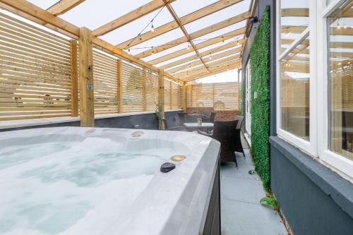 a hot tub in a room with a window at Hambleton House in Derby