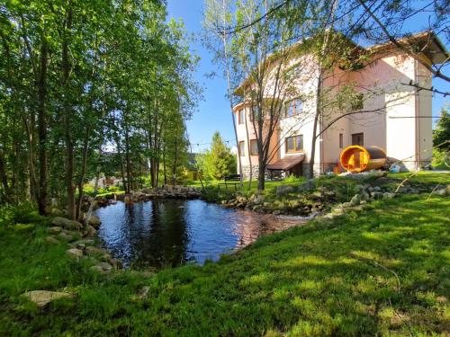 a house with a stream in front of a building at Pionier in Starý Smokovec