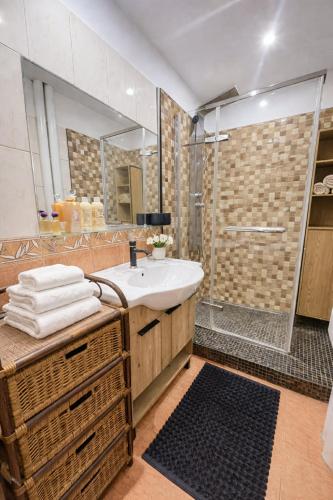 a bathroom with a sink and a shower at Apartman Cañas Zelená Víla in Rimavská Sobota