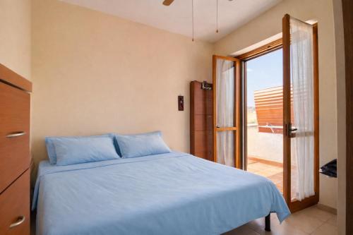 a bedroom with a blue bed and a sliding glass door at Dimora del Sole in Vasto