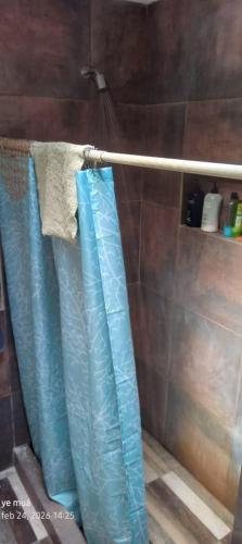 a bathroom with blue shower curtains on a rack at Ye muá, ye tuá in City Bell