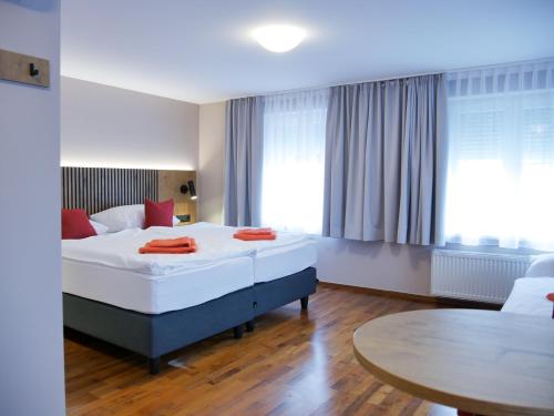 a hotel room with a bed and a table at Hotel Linde-Sinohaus in Lustenau