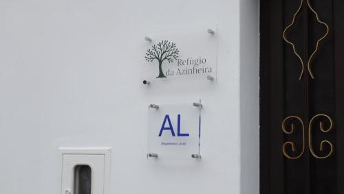 a white wall with a sign on a wall at Refúgio da Azinheira in Torrão