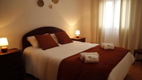 a bedroom with a large bed with two towels on it at Refúgio da Azinheira in Torrão