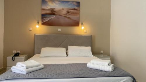 a bedroom with a bed with two towels on it at Akrogiali Hotel in Agios Sostis