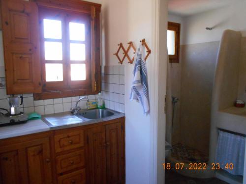 a kitchen with a sink and a window and a refrigerator at PATMOS Mathios Studios- apartments in Patmos