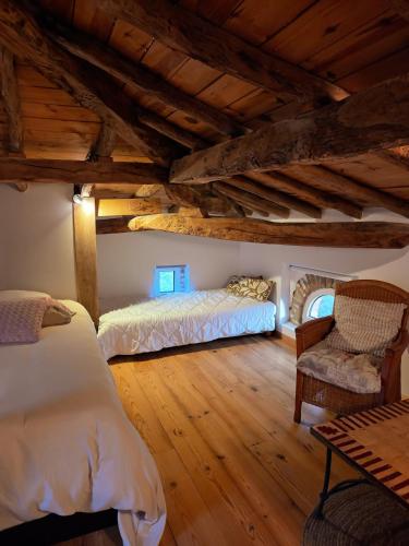a bedroom with two beds and a chair at 3 chambres d'hôtes de charme avec jacuzzi & sauna au Clos de la Lèze in Lézat-sur-Lèze