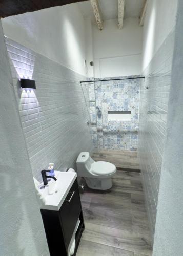 a white bathroom with a toilet and a sink at Suite Matlazinca by Casa Bravo in Toluca