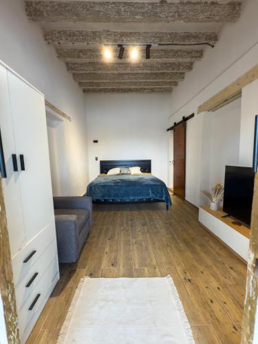 a bedroom with a bed and a couch and a television at Suite Matlazinca by Casa Bravo in Toluca