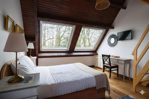 a bedroom with a bed and a desk and windows at Bed and Breakfast Saultchevreuil in Villedieu-les-Poêles