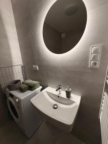 a bathroom with a white sink and a mirror at home&stay - free parking in Trenčín