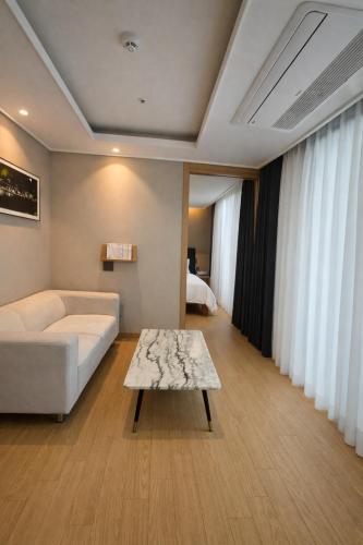a living room with a couch and a coffee table at Haeundae Elbonz in Busan