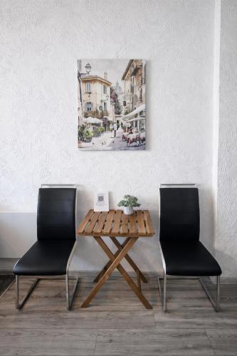 a table and two chairs in a room with a painting at Apartament Fantazja in Przemyśl