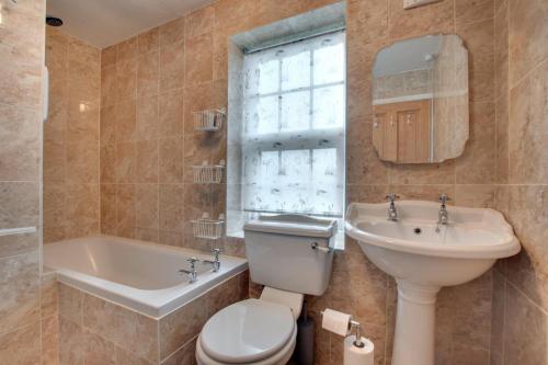 a bathroom with a toilet and a sink and a tub at 2 Bed in Askrigg oc-ds1019 in Askrigg