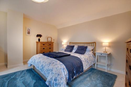 a bedroom with a bed with a blue bedspread and blue rugs at 2 Bed in Askrigg oc-ds1019 in Askrigg