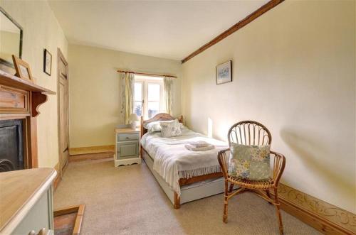 a bedroom with a bed and a chair and a window at 2 Bed in Bodham oc-1660 in Bodham