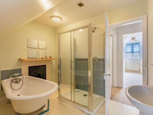 a bathroom with a tub and a shower and a sink at 5 Bed in Swanage oc-dc060 in Swanage