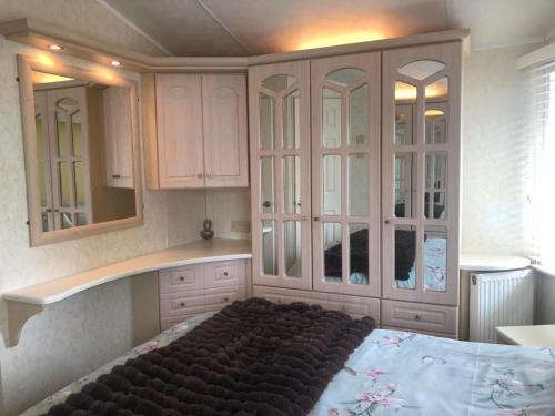 a bedroom with white cabinets and a large bed at 29 The Beeches in Gilcrux