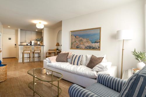 a living room with a white couch and a table at Luxury Rooftop Pool & Dock Steps to Downtown in Annapolis