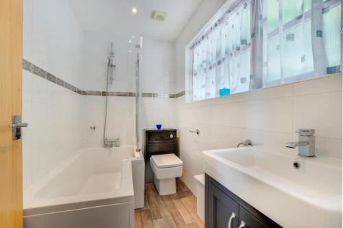 a bathroom with a tub and a toilet and a sink at 2 Bed in Little Petherick oc-p00635 in Little Petherick