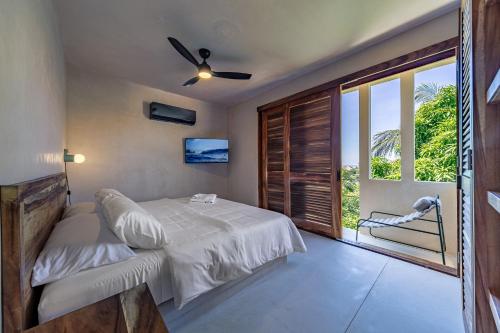 a bedroom with a bed and a large window at Condominios Punta Morelos in Brisas de Zicatela