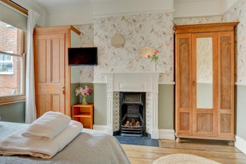 a bedroom with a fireplace and a bed at 6 Bed in Cromer oc-1996 in Cromer