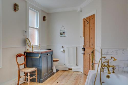 a bathroom with a tub and a chair and a toilet at 6 Bed in Cromer oc-1996 in Cromer