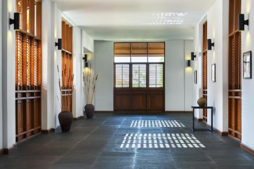 a hallway with a door and a tile floor at The Lake Garden Hotel Nay Pyi Taw - MGallery Collection in Nay Pyi Taw