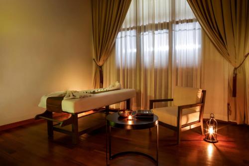 a living room with a couch and a table at The Lake Garden Hotel Nay Pyi Taw - MGallery Collection in Nay Pyi Taw