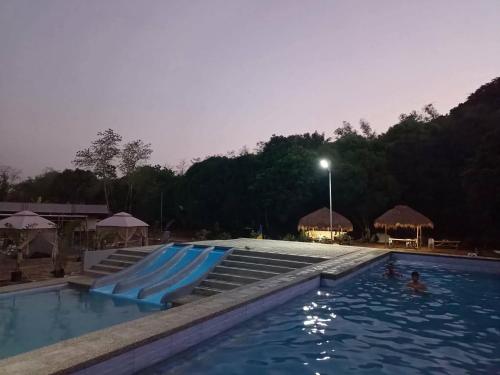 a swimming pool with blue slides in the water at Skybloom Farm Resort in Balasic