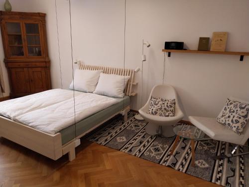 a bedroom with a bed and a chair in it at Königliche Villa - Watzmannblick - nahe Zentrum und Bahnhof in Berchtesgaden