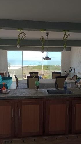 a kitchen with a counter with a view of the beach at Casa da barra in Canguaretama