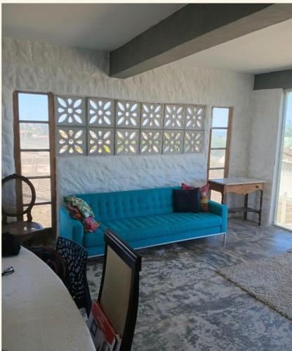 a living room with a blue couch and a table at Casa da barra in Canguaretama