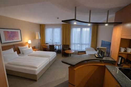 a hotel room with a bed and a table at Best Western Premier Airporthotel Berlin in Schönefeld