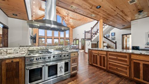 a kitchen with a stove and wooden cabinets at New Unbelievable Views Gourmet Kitchen Firepit in Broken Bow