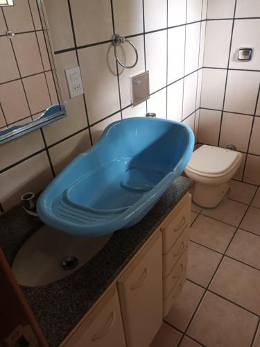 a bathroom with a blue sink and a toilet at Sobrado sustentavel e ecológico alugo casa de hóspedes setor campinas in Goiânia