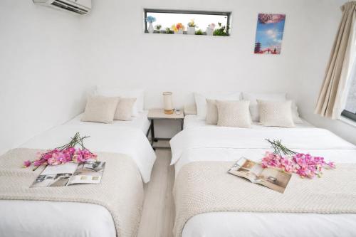 two beds in a room with flowers on them at Free parking for compact cars 4 minutes walk from Kawaguchi Newly built three-story single-family house with 78 square meters 18 minutes by train to Ueno in Kawaguchi