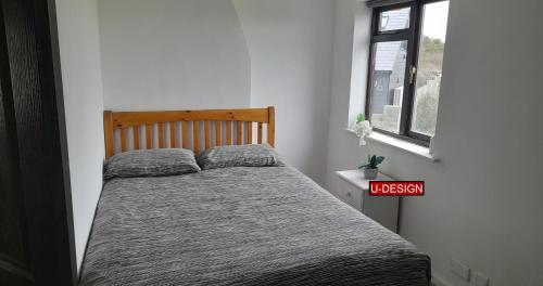 a bed in a white room with aigil at The Green Yard - Ebike Available for Guests in Sundon