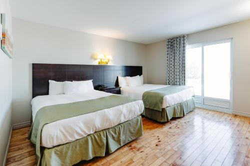 a hotel room with two beds and a window at Mon Joli Motel in Sainte-Flavie
